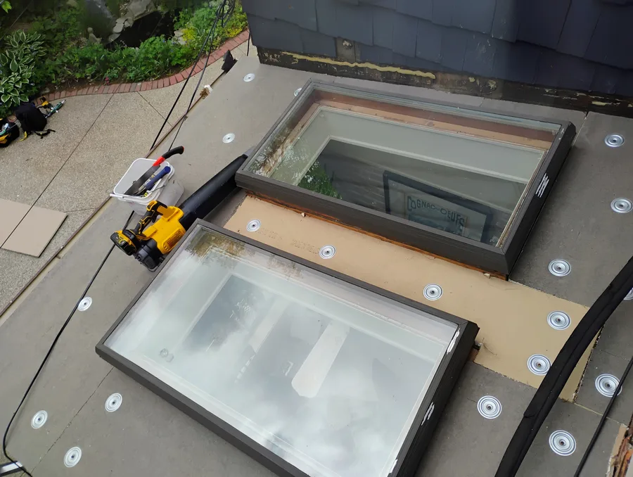 Dual skylight replacement on flat roof with new membrane and curb flashing, Metro Detroit