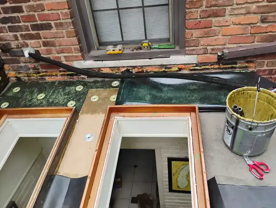 Skylight curb waterproofing detail showing new EPDM flashing and copper frame installation at brick home, Metro Detroit